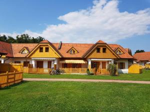 a large yellow house with a fence in the yard at TULPIKA 13 in Moravske-Toplice