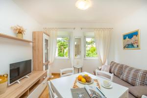 a living room with a television and a table with fruit on it at The Loft in Dubrovnik