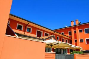 バッサーノ・デル・グラッパにあるHotel Ristorante Al Bassanelloの傘を前に置いたオレンジ色の建物