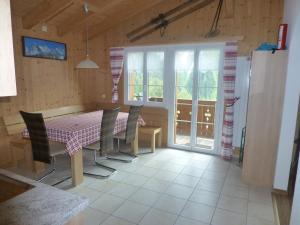 a dining room with a table and chairs and windows at Chalet Verbrunnenhaus Grindelwald in Grindelwald