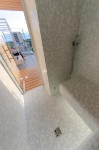 a bathroom with a shower and a staircase with a balcony at Soleis Sea View Spa Apartment in Lignano Sabbiadoro