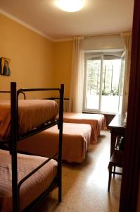 um quarto com 3 beliches e uma janela em Cittadella Ospitalità em Assis