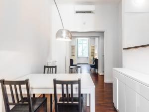 eine Küche und ein Esszimmer mit einem weißen Tisch und Stühlen in der Unterkunft easyhomes-Majno in Mailand
