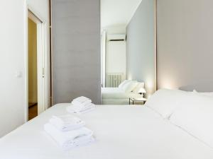 ein weißes Schlafzimmer mit 2 Betten und einem Spiegel in der Unterkunft easyhomes-Majno in Mailand