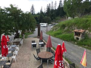 a group of tables and chairs with umbrellas at Le Ranch in La Bollène-Vésubie