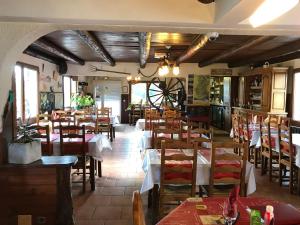 um restaurante com mesas e cadeiras num quarto em Le Ranch em La Bollène-Vésubie