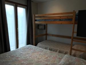 a bedroom with two bunk beds and a window at Le Ranch in La Bollène-Vésubie