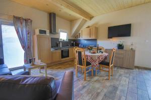 ein Wohnzimmer mit einem Tisch und einer Küche in der Unterkunft Gite au pré des Oies in Ostheim