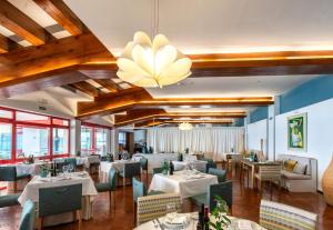 a restaurant with tables and chairs and a chandelier at Parador de Nerja in Nerja