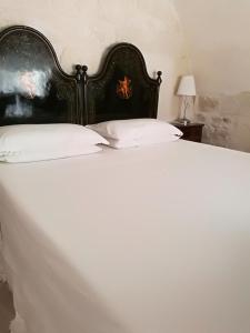 een groot bed met een zwart hoofdeinde en witte kussens bij Ed.Ma in Scicli
