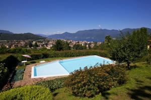 ein Schwimmbad auf einem Hügel mit einer Stadt in der Unterkunft Residenza Moncucco in Luino