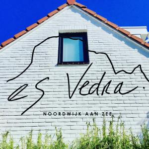 un panneau sur le côté d'un bâtiment blanc avec une fenêtre dans l'établissement Es Vedra, à Noordwijk aan Zee