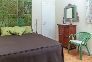 um quarto com uma cama, uma cadeira e um espelho em Kalsa Casa di Charme con terrazza by Wonderful Italy em Palermo