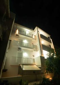 a white building with a balcony at night at Stefanos Family Apartments in Moírai