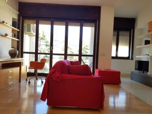 a living room with a red chair and a large window at Il Campanile in Vico Equense