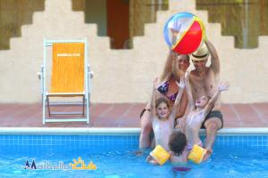 un grupo de personas jugando con una pelota de playa en una piscina en Villaggio Marbella Club, en Palinuro