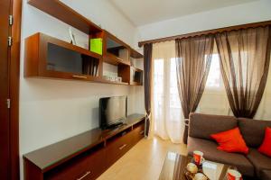 a living room with a couch and a tv at Stefanos Family Apartments in Moírai