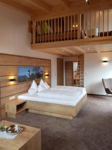 a bedroom with a large white bed and a loft at Pension Bauernhof Spielmann in Mieming