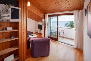 a living room with a view of the ocean at Apartmani Denis Vela in Podgora