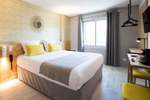 Pokój hotelowy z dużym łóżkiem z żółtymi poduszkami w obiekcie T Boutique Hotel w Arcachon