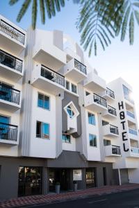 ein weißes Gebäude mit einem Balkon und einer Palme in der Unterkunft T Boutique Hotel in Arcachon