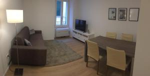 a living room with a table and a couch and a television at Riva Guest House Apartment in Riva del Garda