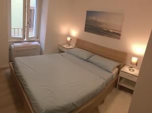 a small bedroom with a bed and two night stands at Riva Guest House Apartment in Riva del Garda
