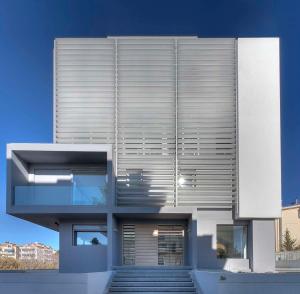 una casa moderna con una escalera delante de ella en Brand new budget apartment next to Iaso and Oaka, en Atenas