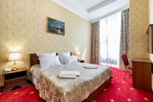 ein Hotelzimmer mit einem Bett mit Handtüchern darauf in der Unterkunft Hotel MANO in Kasan