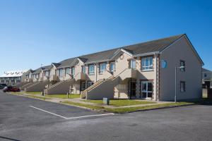 a row of houses in a parking lot at Kilkee Holiday Homes (1st Floor) in Kilkee