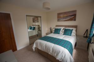 a bedroom with a large bed and a mirror at Golfview in Buckie