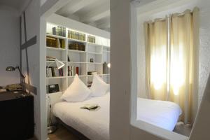 a bedroom with a bed with white pillows and a window at COLMAR city center place de l'Ancienne Douane - Apartment "MARIE" - in Colmar