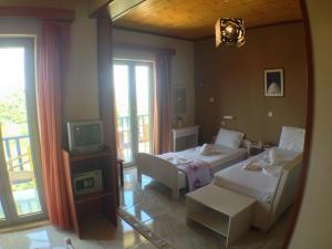 a bedroom with a bed and a tv and a couch at Politia Hotel in Agios Nikitas