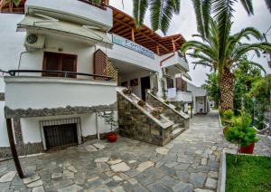 a house with a stone walkway in front of it at Fantasia Studios and Apartments in Neos Marmaras
