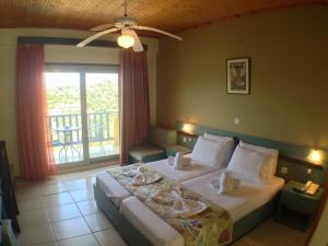 a hotel room with a bed and a balcony at Politia Hotel in Agios Nikitas +37 photos