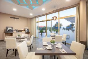 a dining room with tables and chairs and a large window at Hotel Admiral San Roque in San Roque