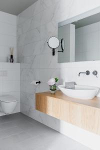 ein weißes Badezimmer mit Waschbecken und Spiegel in der Unterkunft Boutique Hotel Catshuis in Leeuwarden + 32 Fotos