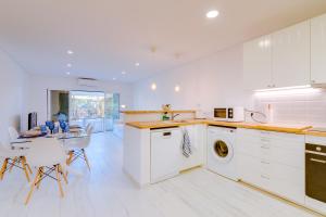 una cocina con armarios blancos y una mesa con sillas. en Villa V1 Vale do Lobo Beach en Vale do Lobo