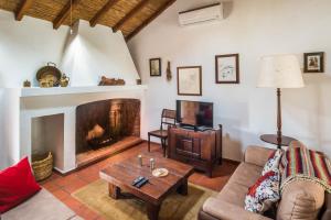 a living room with a fireplace and a tv at Monte Pedras Negras in São Luis