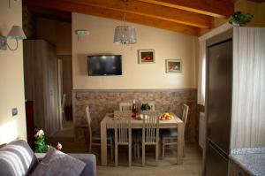a dining room with a table with chairs and a tv at casa oliva la bodegueta in Abiego