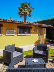 a patio with two wicker chairs and a table at LA BRIGATA APARTMENTS Yellow House in Cavallino-Treporti