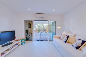 a living room with a white couch and a television at Villa V1 Vale do Lobo Beach in Vale do Lobo