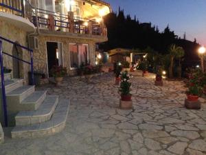 a building with stairs and a stone courtyard at night at Politia Hotel in Agios Nikitas
