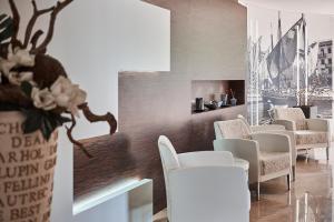 una sala de espera con sillas blancas y chimenea en Hotel Villa Smeralda en Malcesine