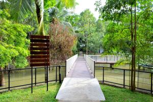 a wooden walkway in a park next to a body of water at Kottawatta Village in Udawalawe