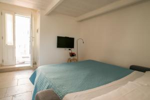 ein Schlafzimmer mit einem Bett und einem TV an der Wand in der Unterkunft Idris Loft Matera in Matera