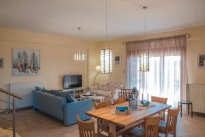a living room with a blue couch and a table at Saint Paul's Residences in Sani Beach