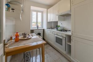 kuchnia z białymi szafkami i drewnianym stołem w obiekcie Pellegrino 75 Double Bedroom w Rzymie