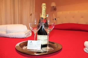 - un plateau avec 2 verres à vin et une bouteille de vin dans l'établissement Passo del Cavaliere, à Tropea