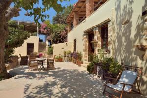 a courtyard of a house with chairs and a table at Elia Hotel & Spa in Áno Voúvai